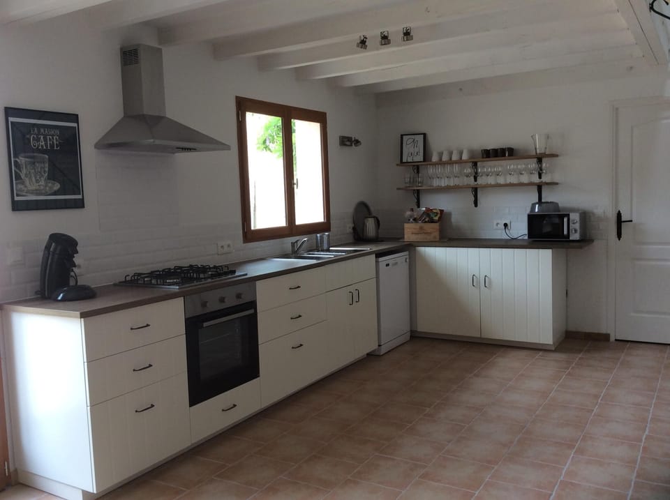Fresh, clean, well equipped kitchen looking onto private outside dining and pool