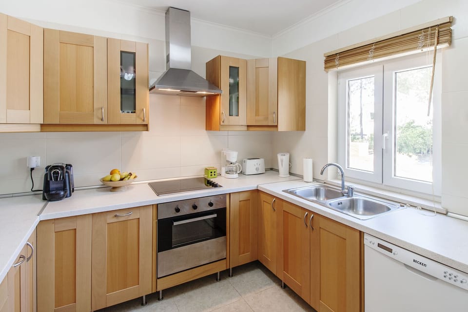 Modern kitchen with wooden cabinets and stainless steel appliances — Quinta do Peru I, holiday villa in Sesimbra