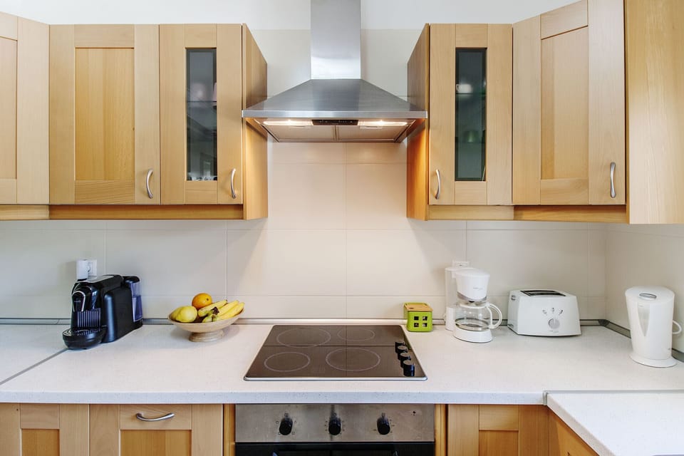 Modern kitchen with wooden cabinetry and stainless steel extractor hood — Quinta do Peru I, holiday villa in Sesimbra
