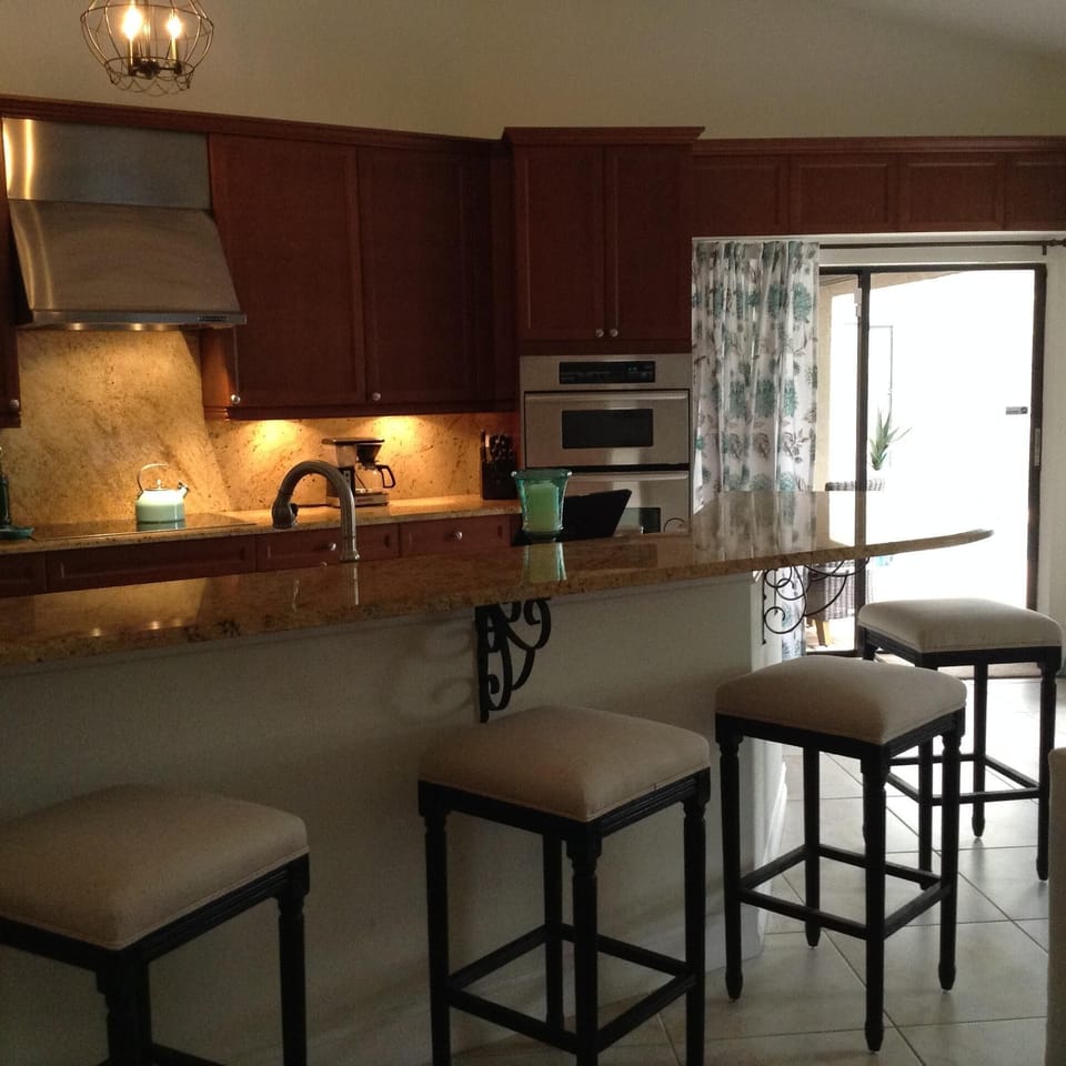 Kitchen with bar and 5 stools.