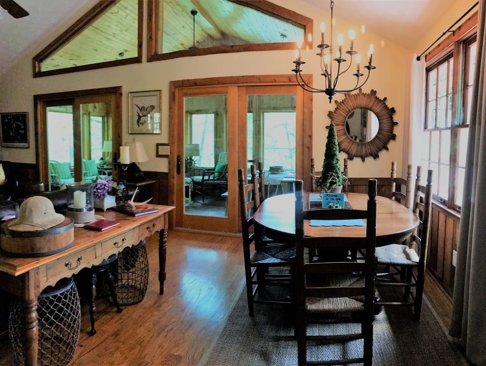 Main living area with dining room looking out to sunporch with view of the lake