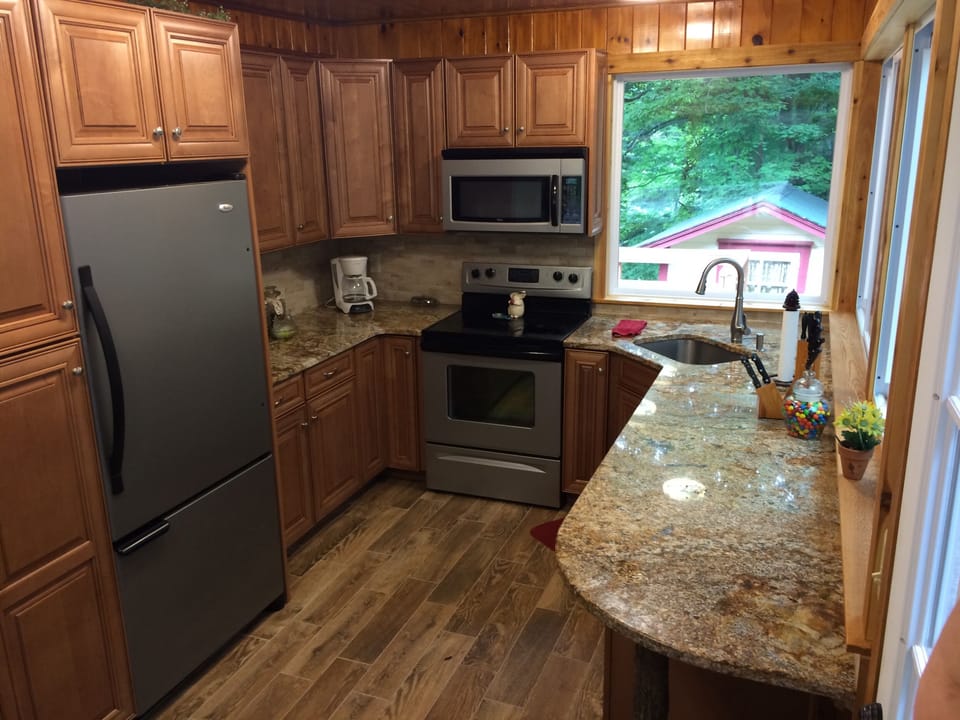 Full Kitchen has picture windows out to screen porch and creek /waterfall views.