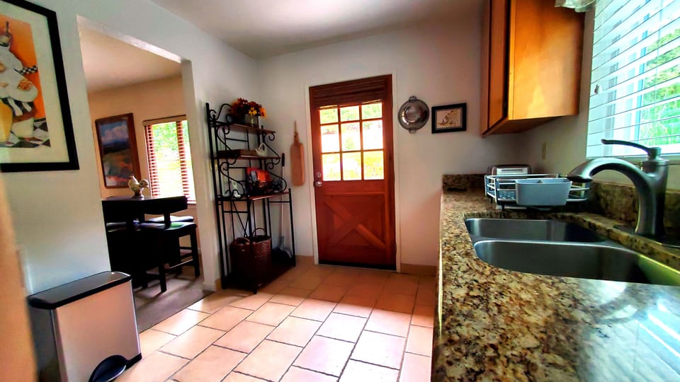 A view of the kitchen, facing the entry to the living room and the kitchen door.