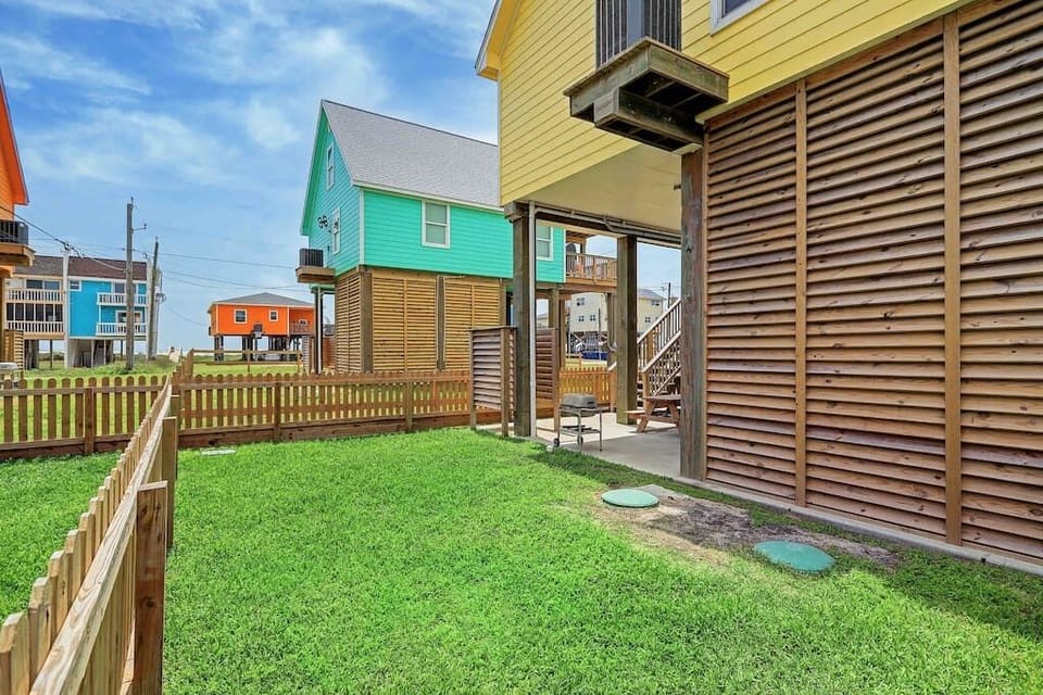 Large backyard with fully enclosed fence for pets or a game of cornhole.