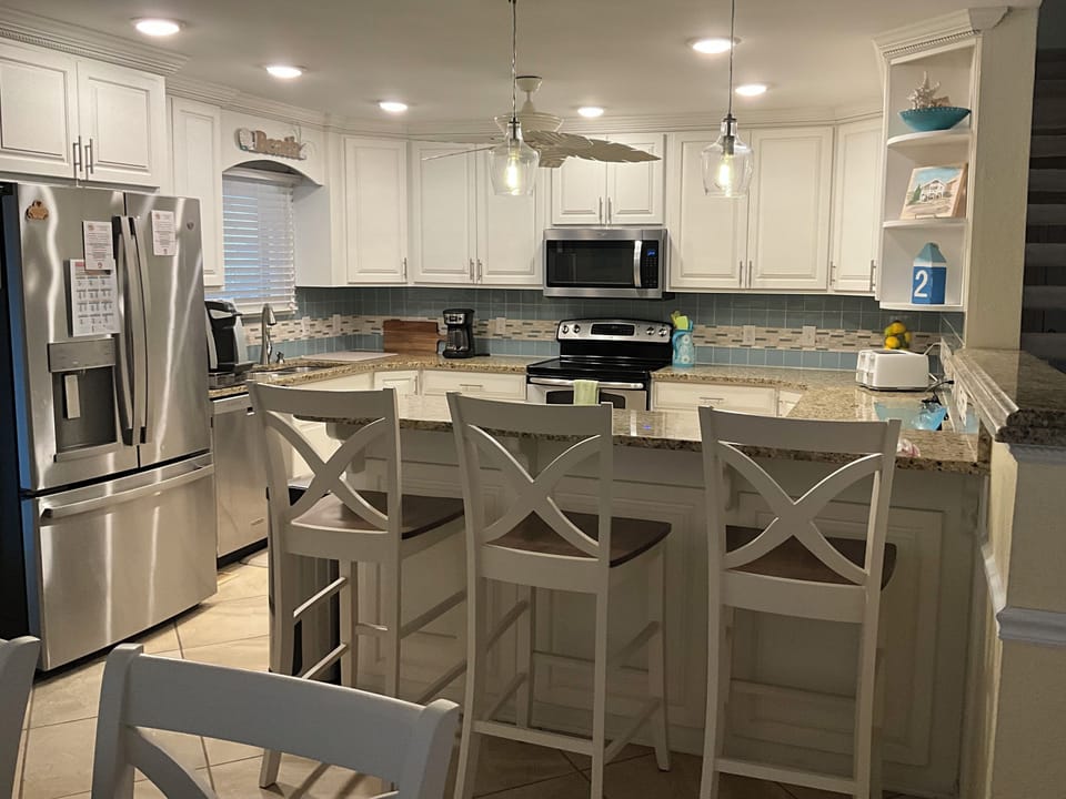 Kitchen w/ granite counter tops and 3 bar stools for additional seating 