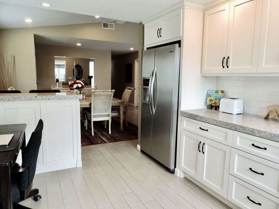 A bar with two comfortable chairs  divides the kitchen from the dining room.