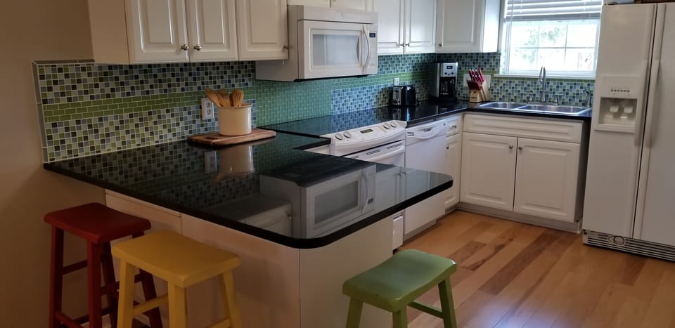 updated kitchen with granite counters and tile backsplash