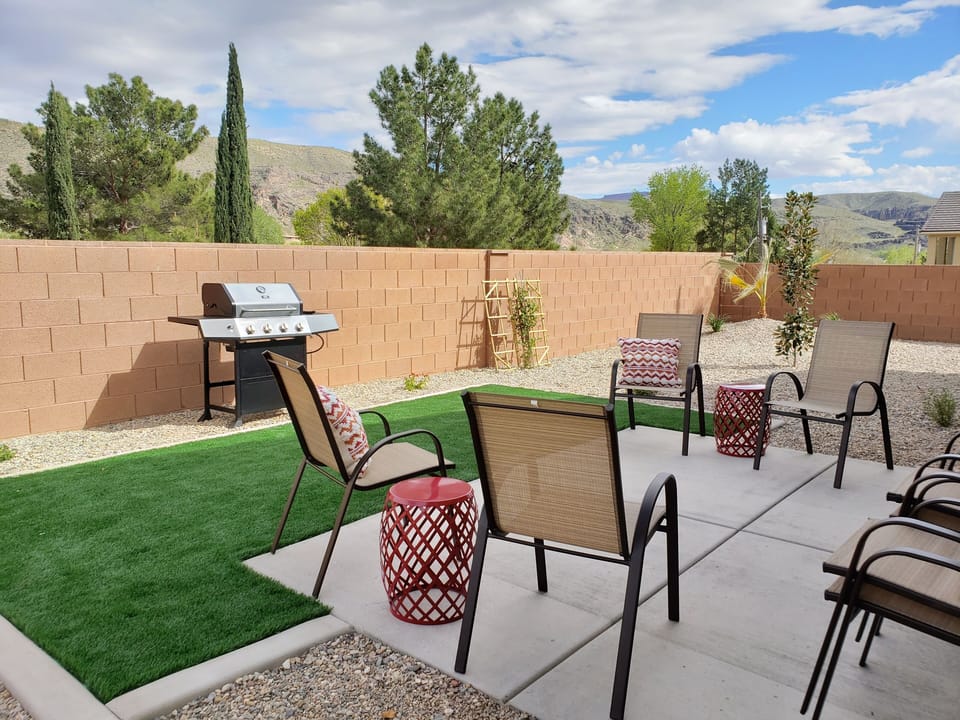 Landscaped backyard with grill and plenty of seating to enjoy the evening shade.