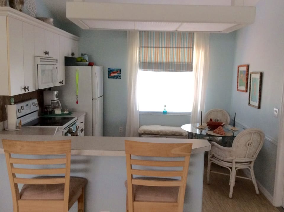 Three bar stools overlooking kitchen offer additional seating.