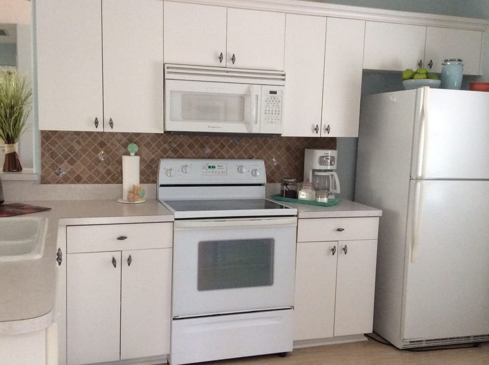 Kitchen is fully equipped for large meal preparation and exits onto lanai. 