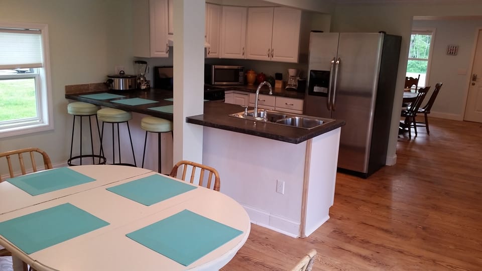 Kitchen is open to both dining room and back patio with eat-in outdoor kitchen.