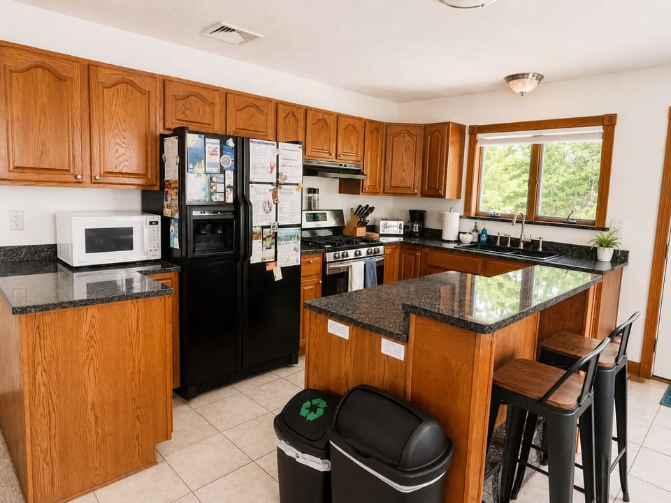 Well-equipped kitchen with gas range, large fridge, and granite countertops