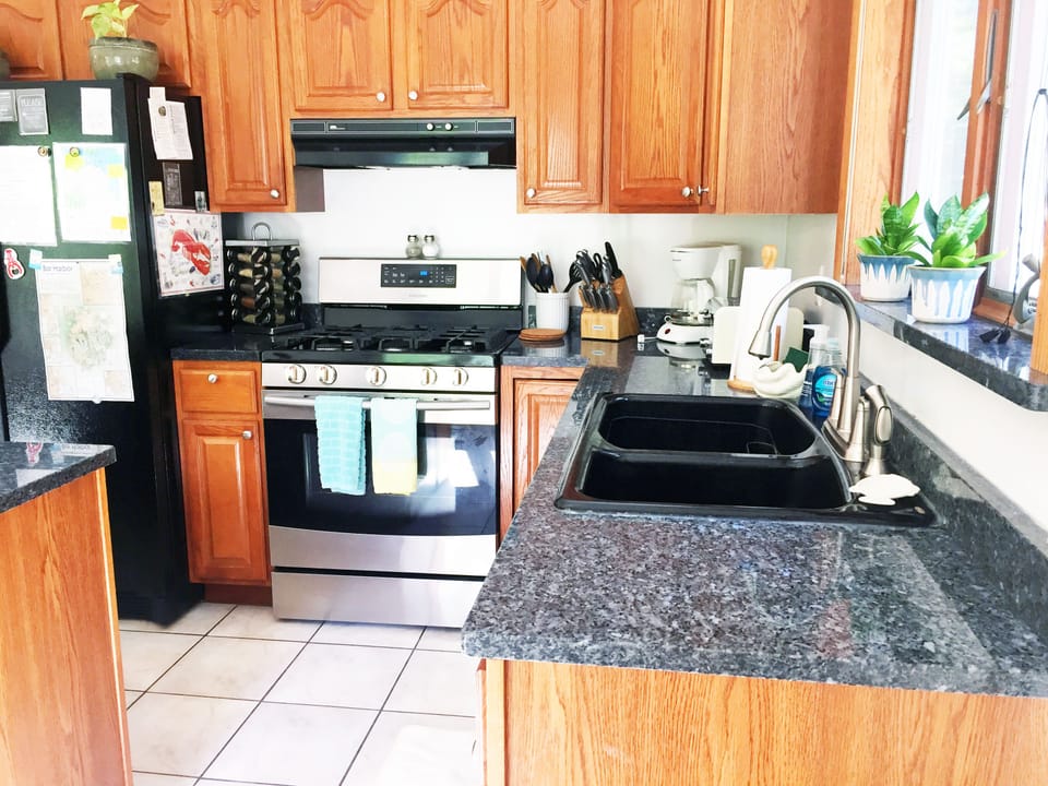 Large, spacious tiled kitchen with granite countertops, island & breakfast bar