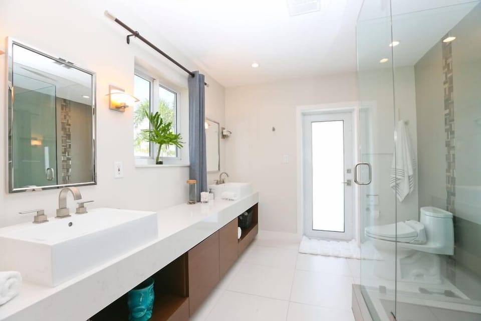 Owners suite bathroom with his and hers sinks and access to the pool area