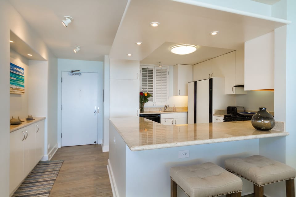 Fully equipped open style kitchen with Crema Marfil counter tops.