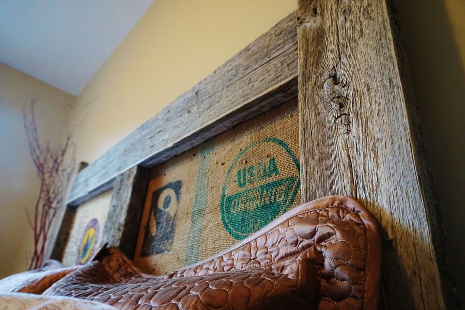 Barnwood bed accented with richly-textured burlap coffee bags
