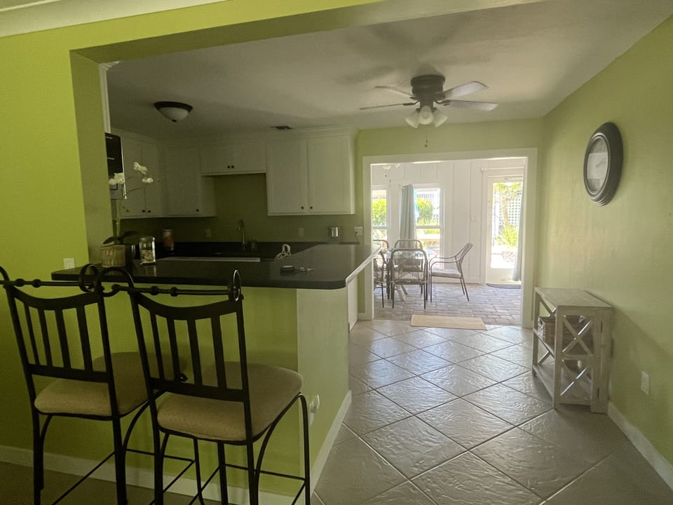 New kitchen with black quartz countertops and new appliances opens to lanai.