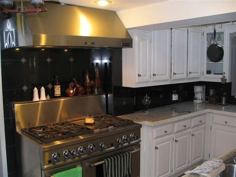 Gourmet style kitchen with stainless steel Jennair stove, dishwasher & 2 refrs