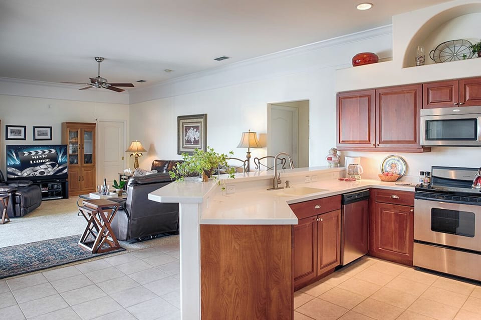 Open-concept kitchen flows into cozy family room, plush seating and a big screen