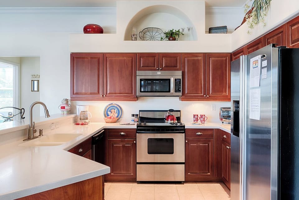 Spacious kitchen with stainless appliances, rich wood cabinets and ample counter