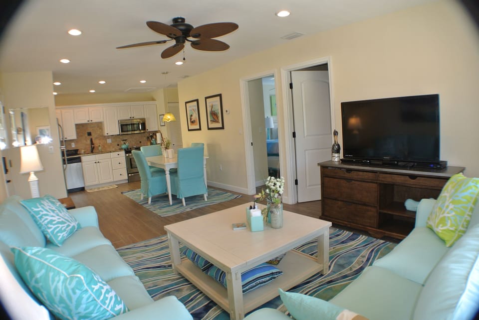 Unit A Open living dining kitchen with both bedroom doors (left of tv) in view.
