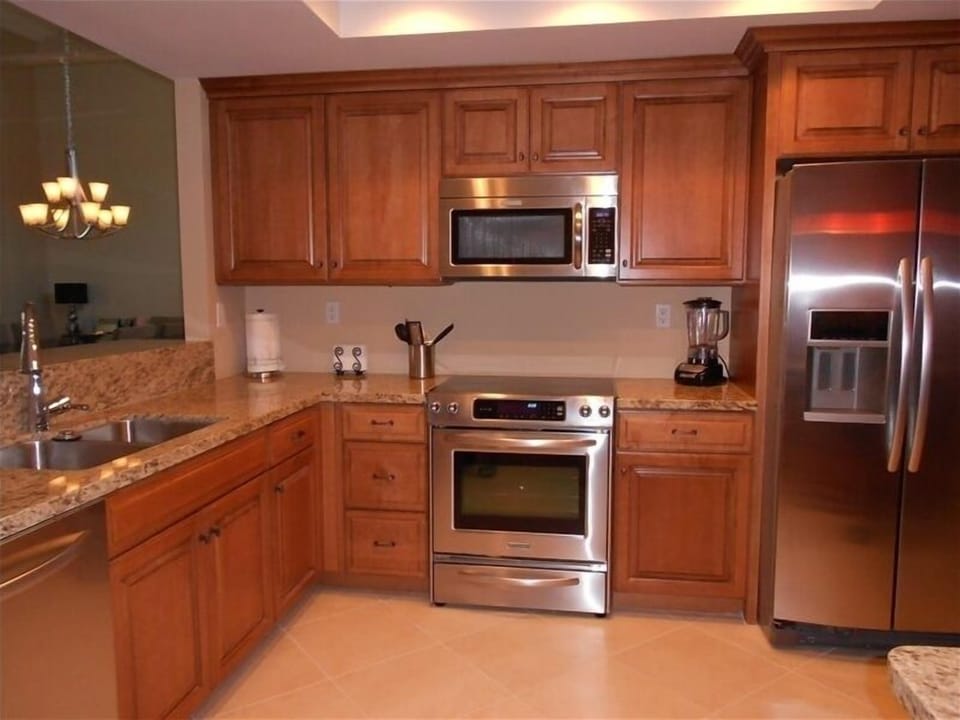 Kitchen with granite counter tops. Den is connected and has a large HDTV 