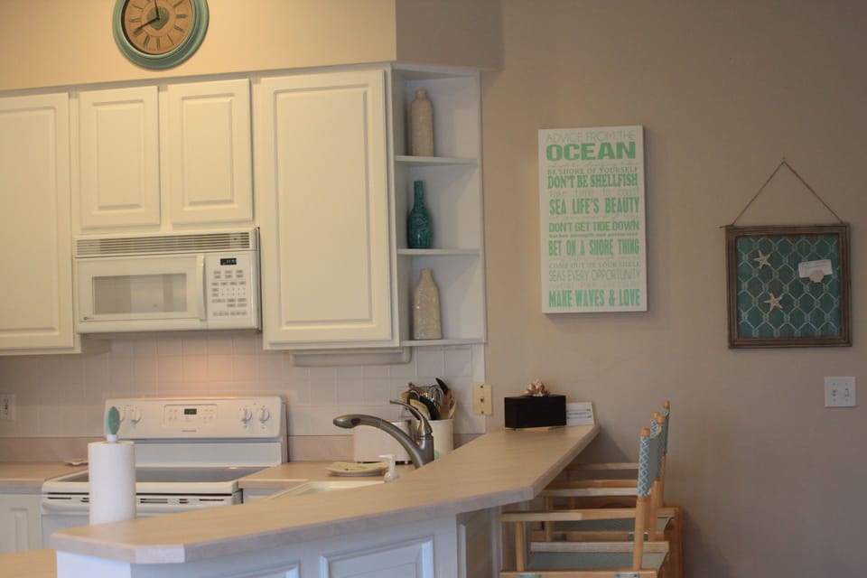 Coastal Kithen area with all appliances and 2 bar stools.