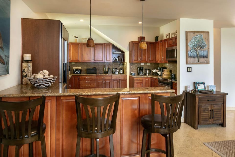 Warm, inviting kitchen with rich wood cabinetry and breakfast bar seating