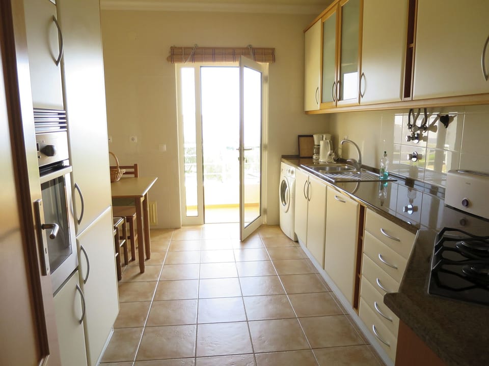 The separate well-equipped streamlined kitchen opens onto the veranda