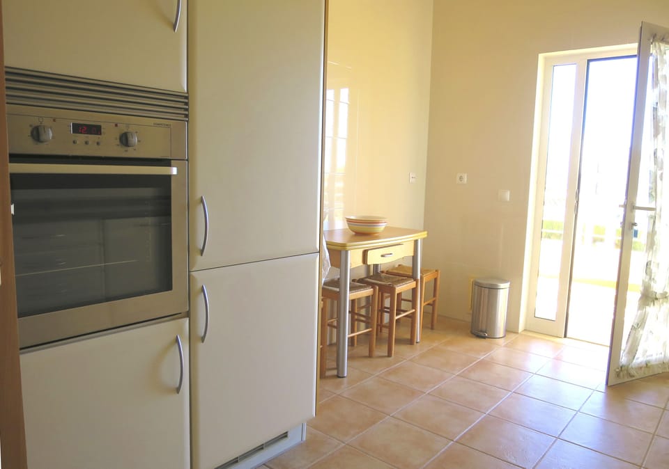 Well-equipped kitchen with breakfast table and access to the long veranda