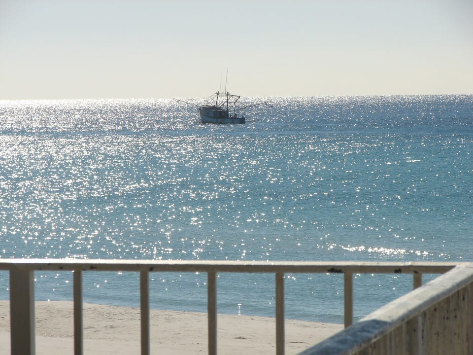Fishing boat seen from the balcony, in the beautiful blue water,