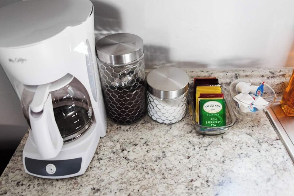 Mr Coffee pot with Folgers coffee, sugar, and creamer.