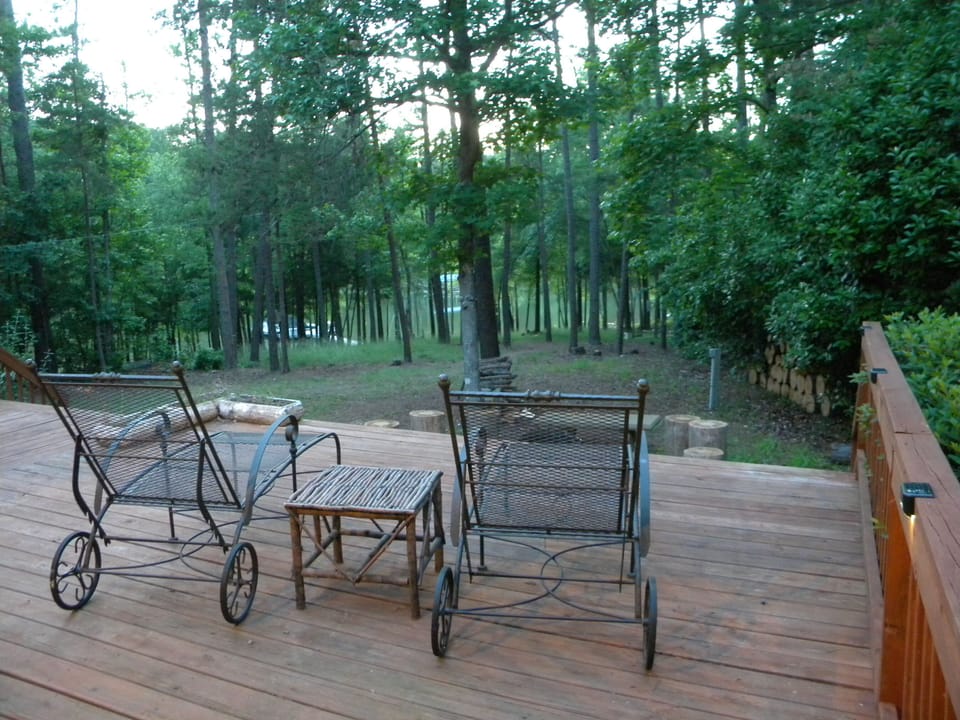 Sprawling deck overlooks a quiet cove, private dock and wooded 3-acre lot