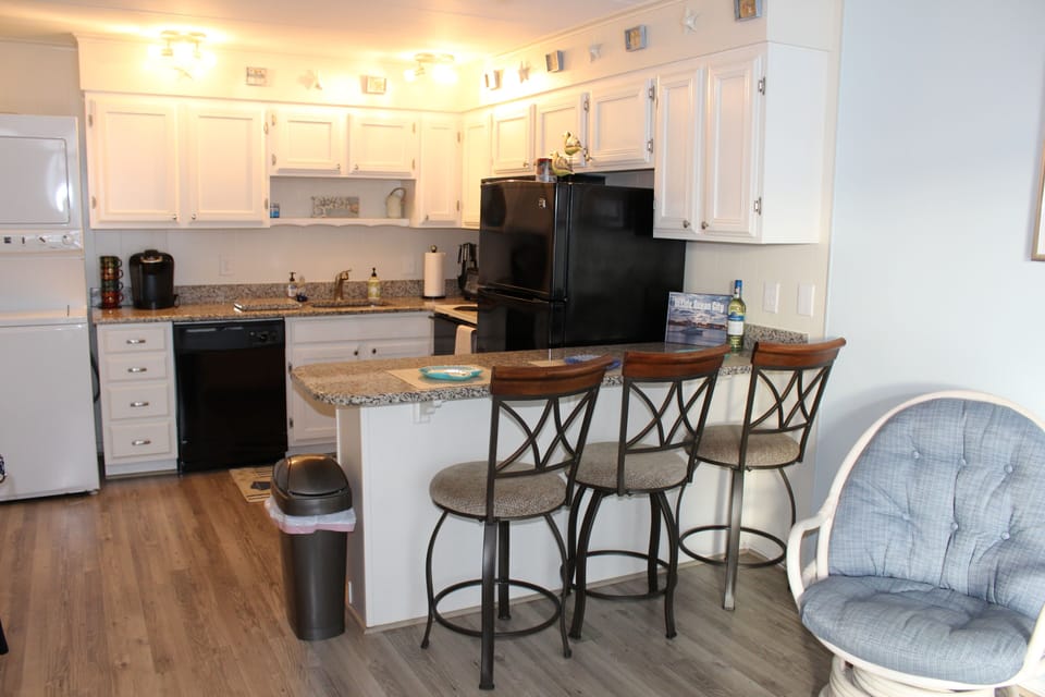 Roomy stocked kitchen with seating at island. Granite countertops.