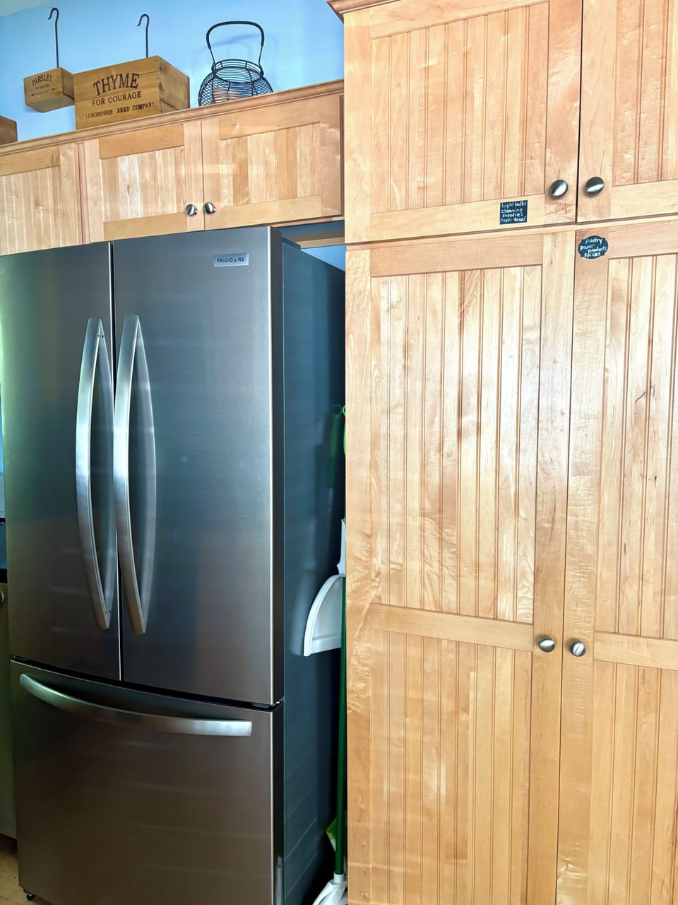 New refrigerator next to the pantry cupboard
