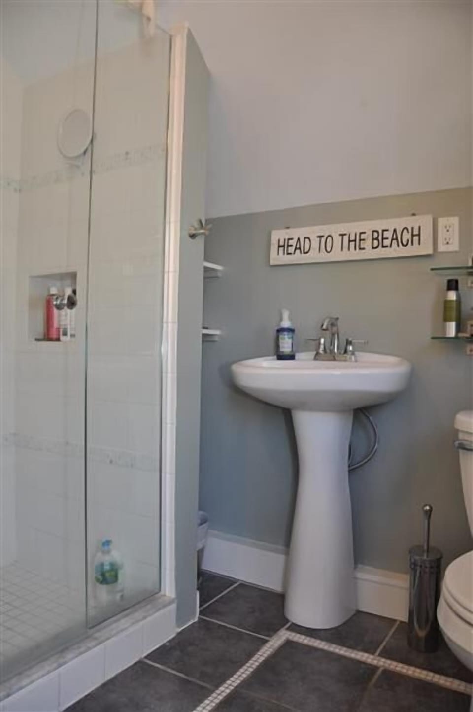 Modern glass door shower with tiled surround.