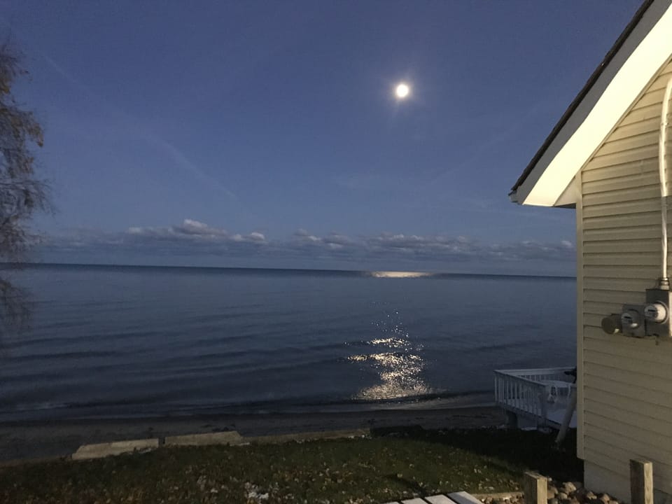 the moon shinning over the lake