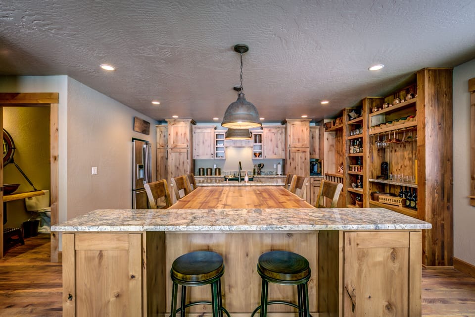 Custom, live-edge timber table, suspended between kitchen island and bar top