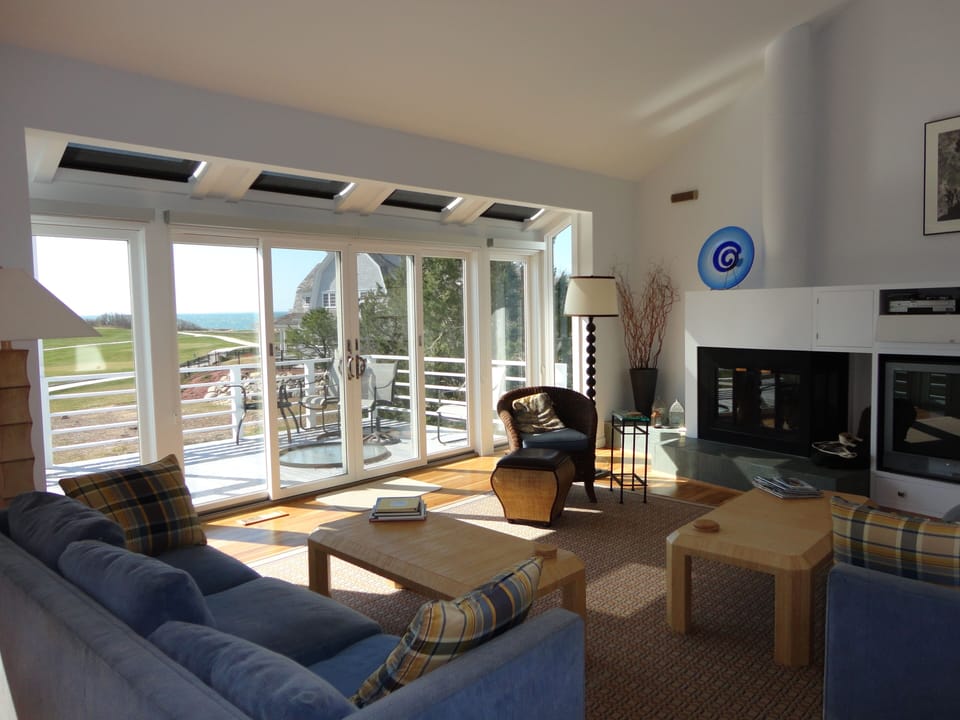Living room wall of windows with sliders to deck