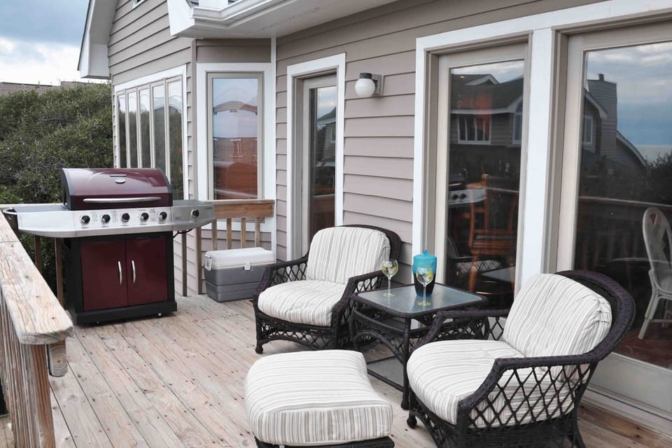 Oceanfront top deck grill & seating area. Door to bar.   MB 1 windows to left
