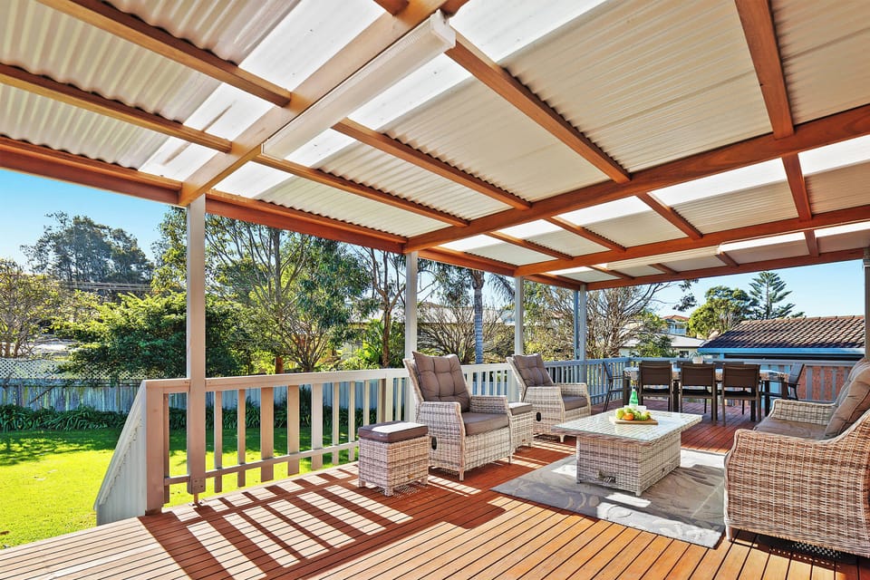 Spacious covered rear patio with outdoor furnishings and bbq