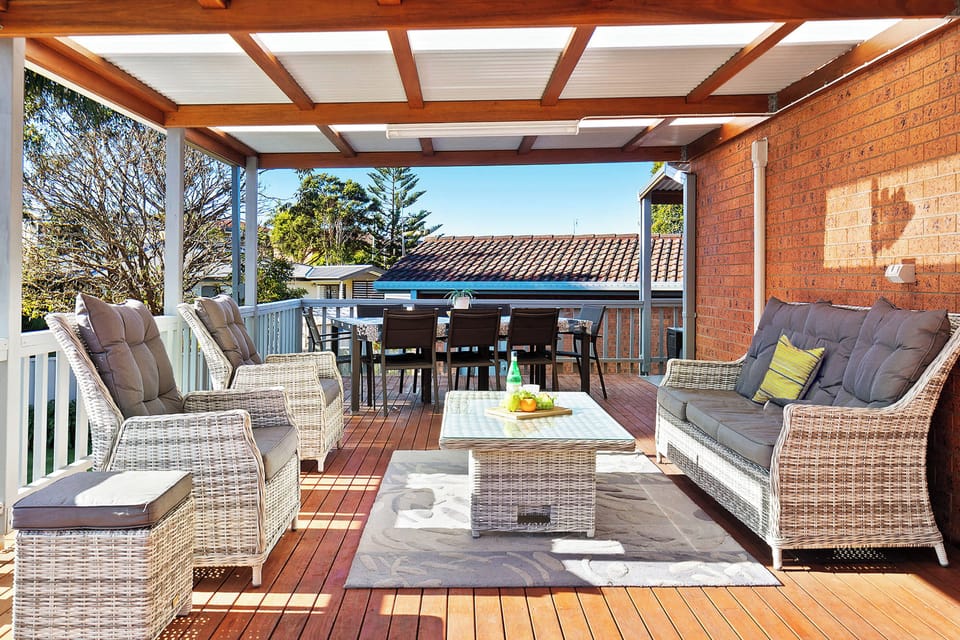 Spacious covered rear patio with outdoor furnishings and bbq