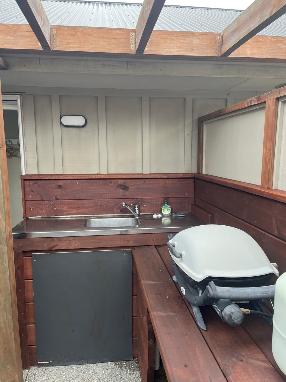 Outdoor sinkbench and Weber barbecue in courtyard.