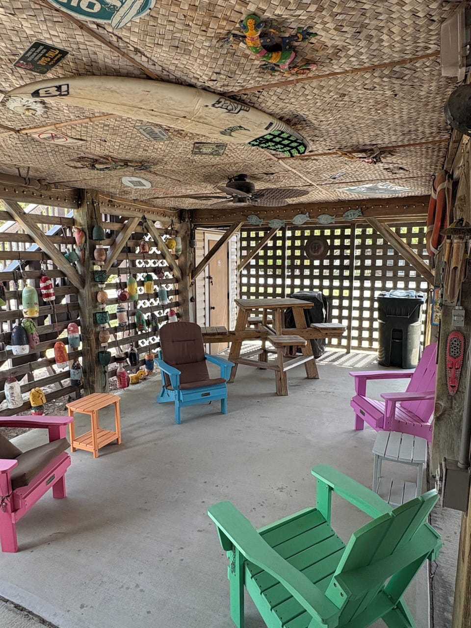 Ground level sitting area under cottage with picnic tables and tv