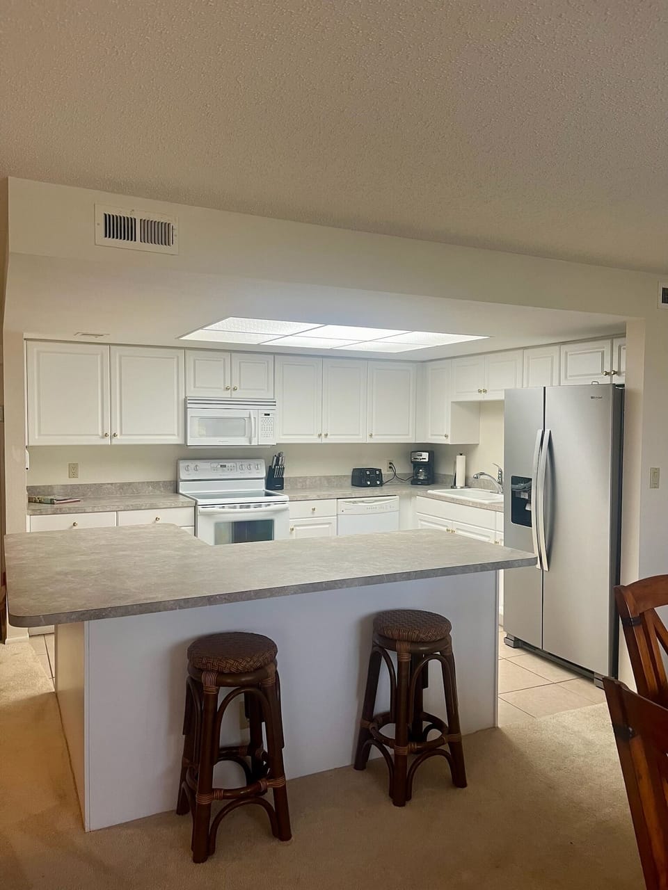 The private kitchen includes an island with two bar stools for extra seating