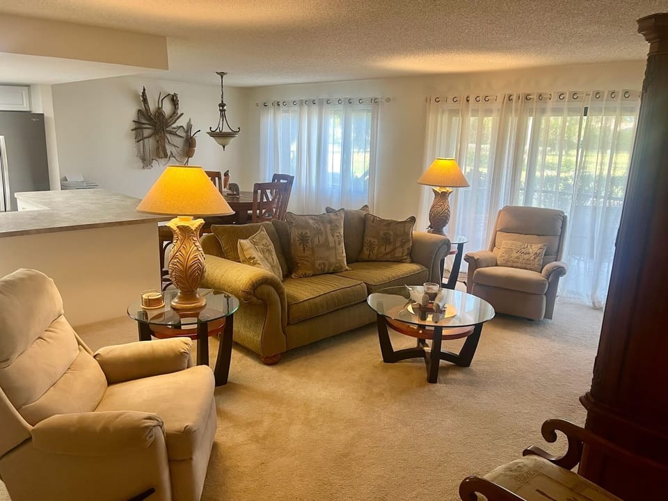 Living room with large entertainment center, smart TV, couch & reclining chairs