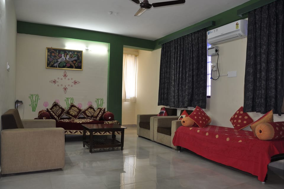 Living Room with two Diwans and a Sofa set with wall mounted TV.