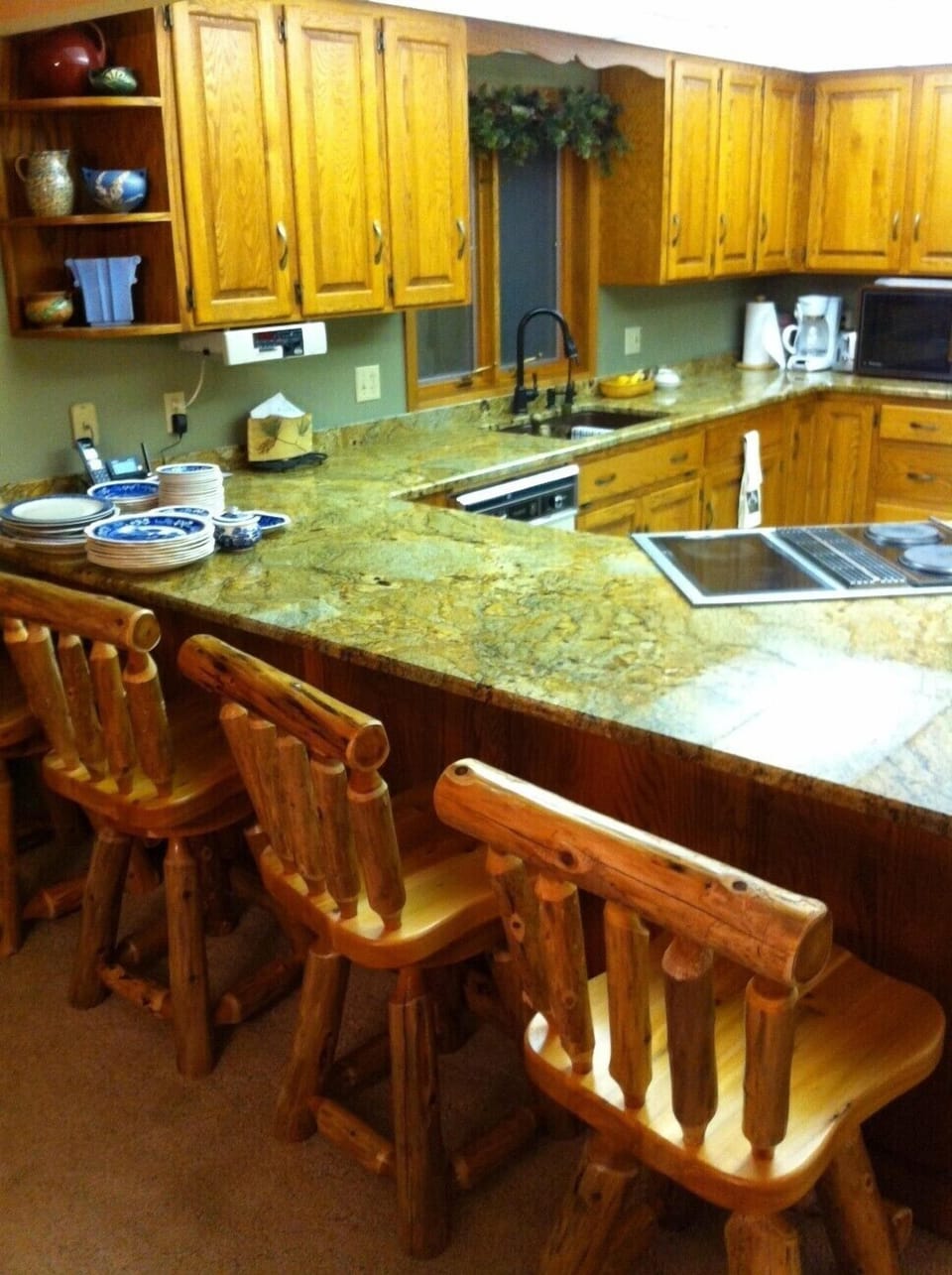 New granite kitchen counter tops with log chairs at the bar 
