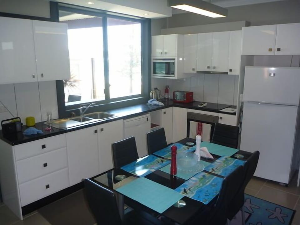 Kitchen with window overlooking beach and servers to master bed balcony 