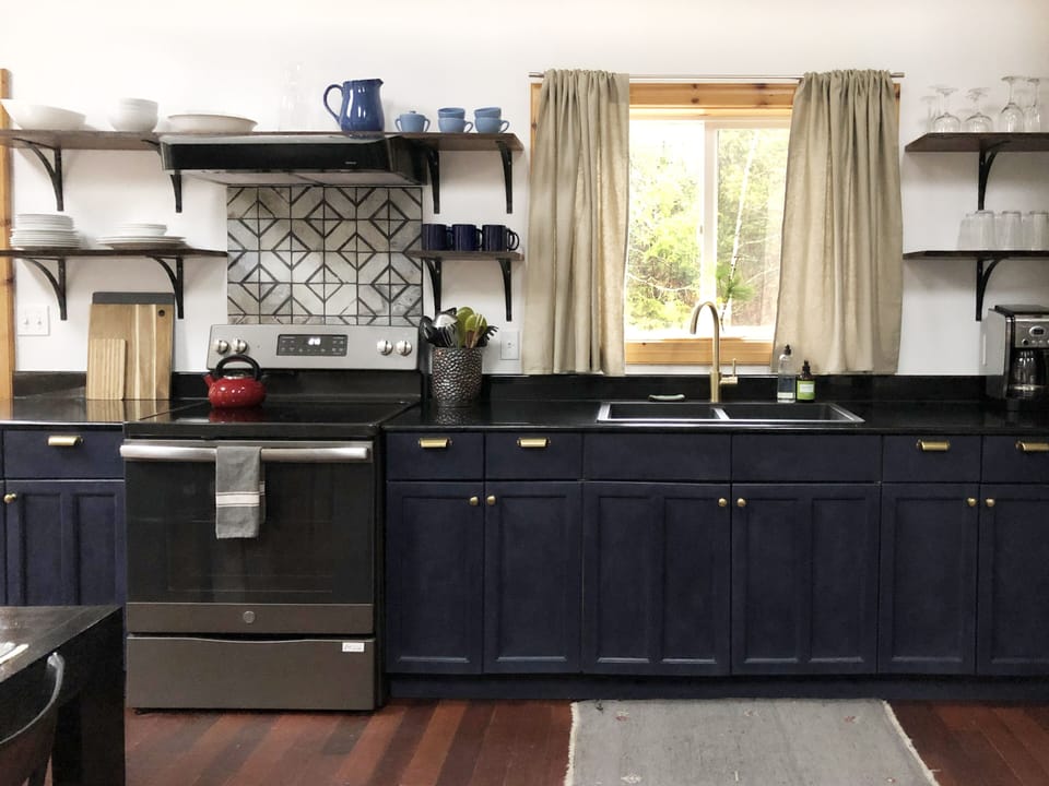 Fully stocked kitchen with pots and pans, utensils and dishware.